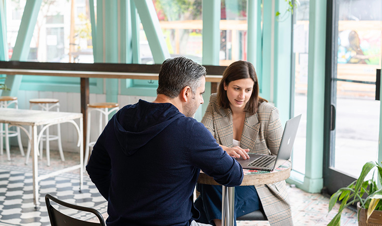 Business meeting with laptop at a table in a cafe